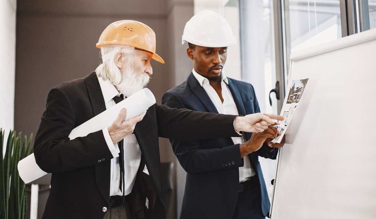 Two construction professionals wearing hard hats and suits